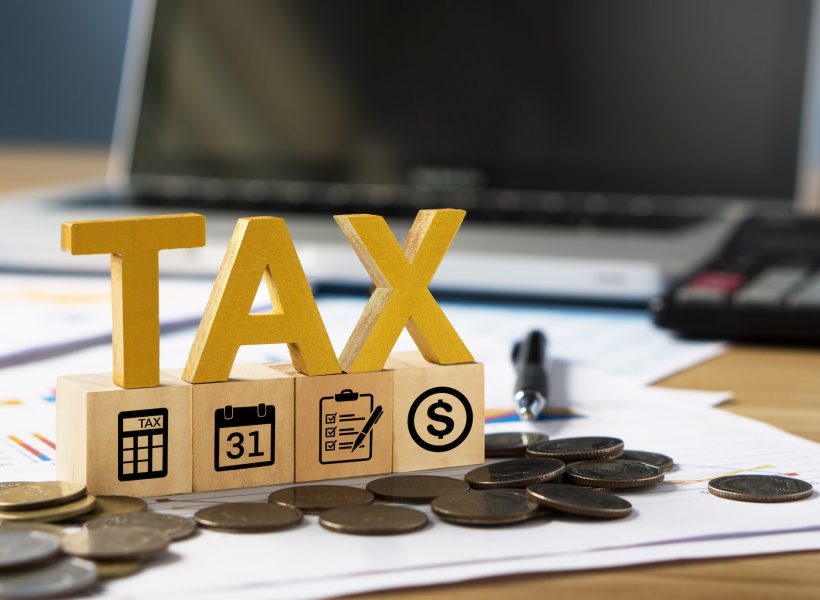 Tax wooden letter and tax icon on wooden block.Pay tax in new year.